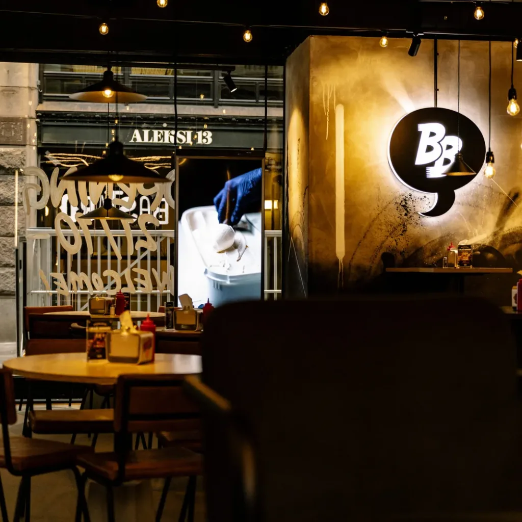 Restaurangmiljö hos Bastard Burgers med takhögtalare och dekorativ belysning